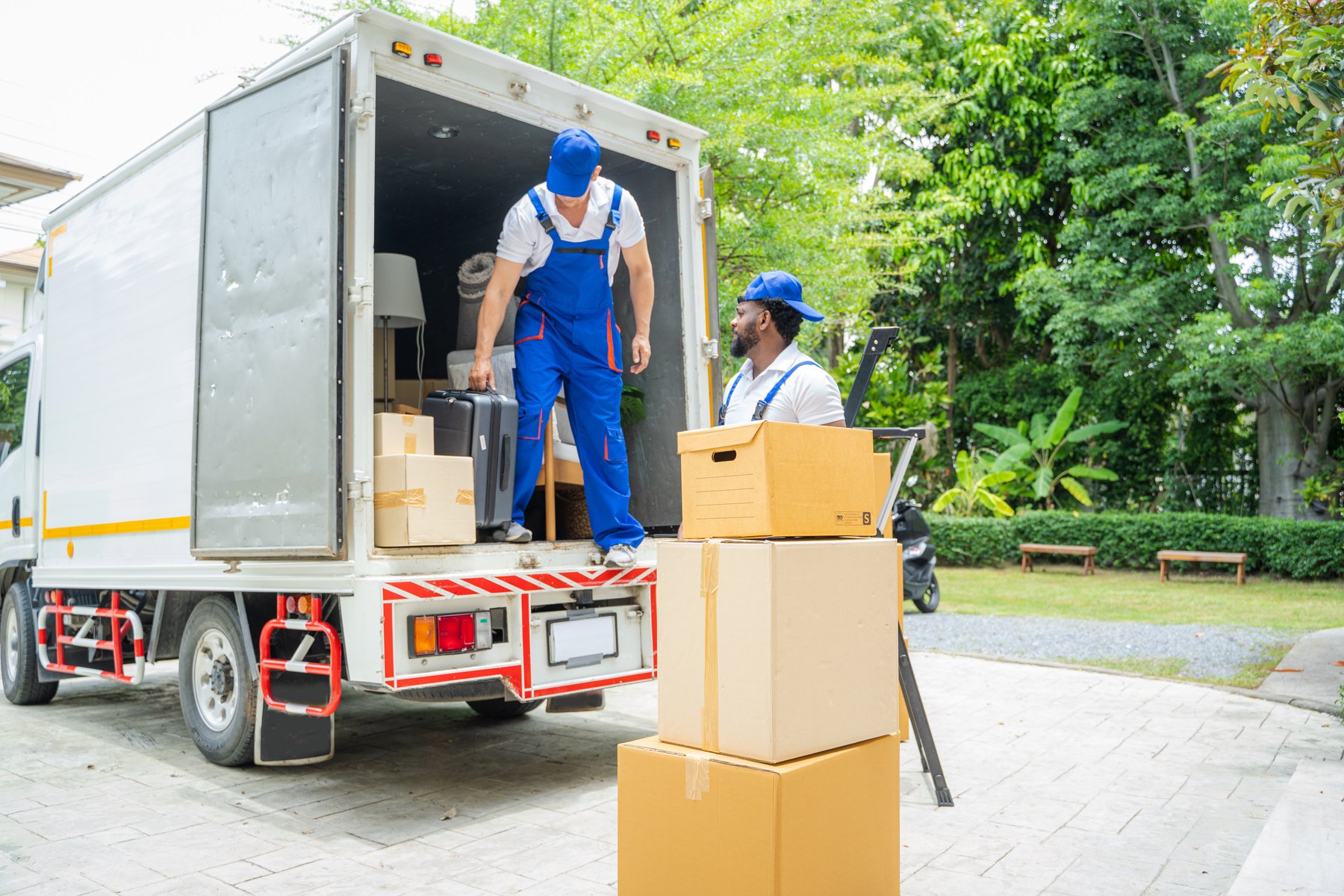 Removal company workers unloading Boxes From Truck Into New Home